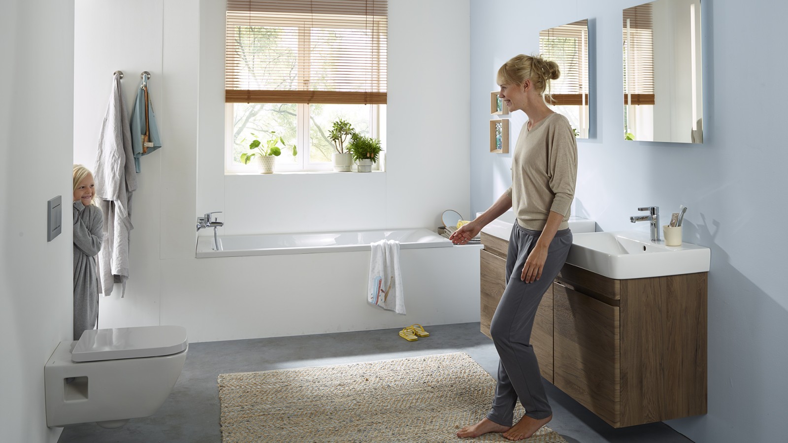 Woman and child standing in a Geberit Renova series family bathroom (© Geberit) Woman and child standing in a Geberit Renova series family bathroom (© Geberit)