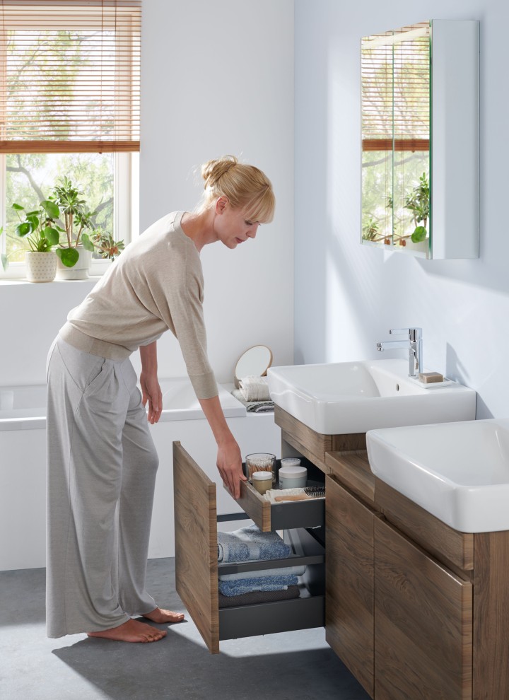 Woman in white bathroom from the Geberit Renova Plan bathroom series Woman in white bathroom from the Geberit Renova Plan bathroom series