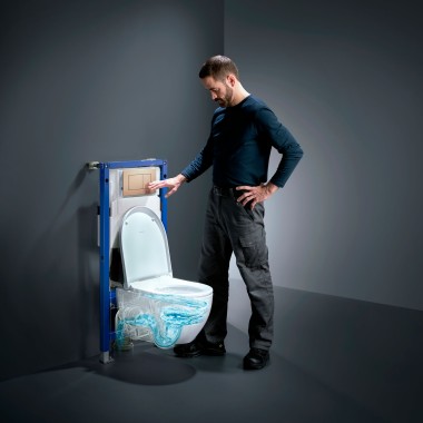 Man next to Geberit Acanto toilet with TurboFlush, new Geberit Duofix and Sigma40 flush plate in rose gold