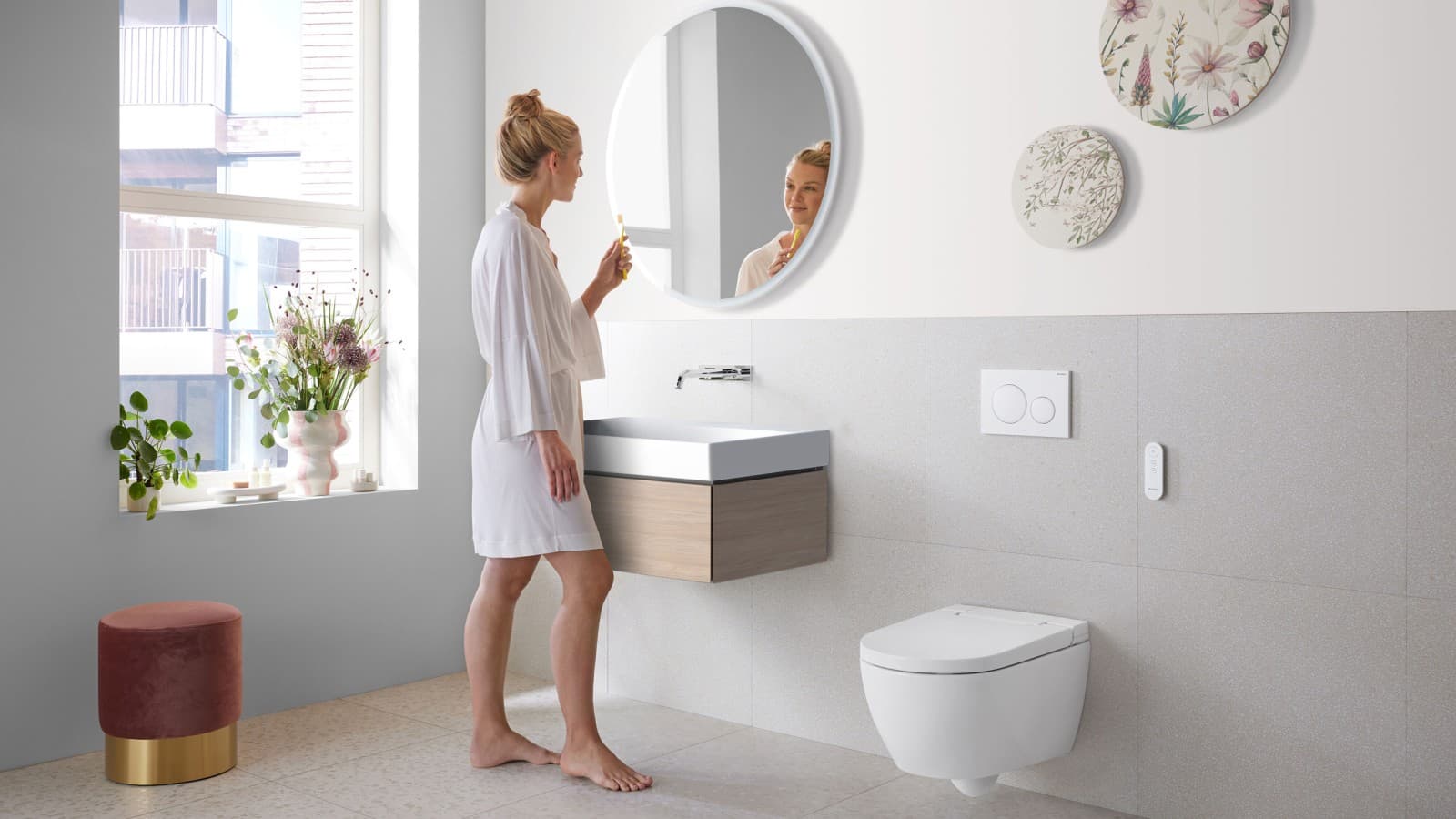 Woman in bathroom with Geberit AquaClean Alba – a cost-effective bidet toilet with spray functionality Woman in bathroom with Geberit AquaClean Alba – a cost-effective bidet toilet with spray functionality